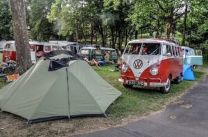 Volkswagen Transporter T1 roșu-alb într-un camping