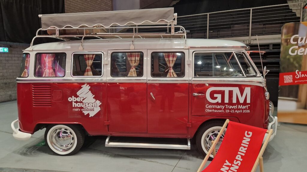 Volkswagen Transporter T1 roșu-alb văzut din față, expus la Germany Travel Mart